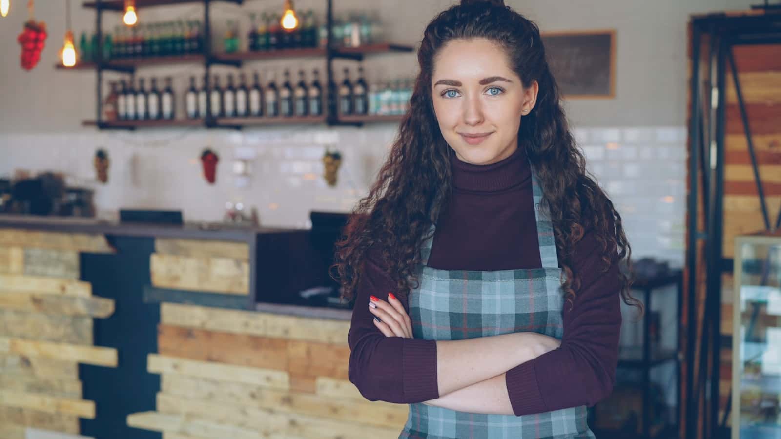 A smiling business owner standing in her coffee shop