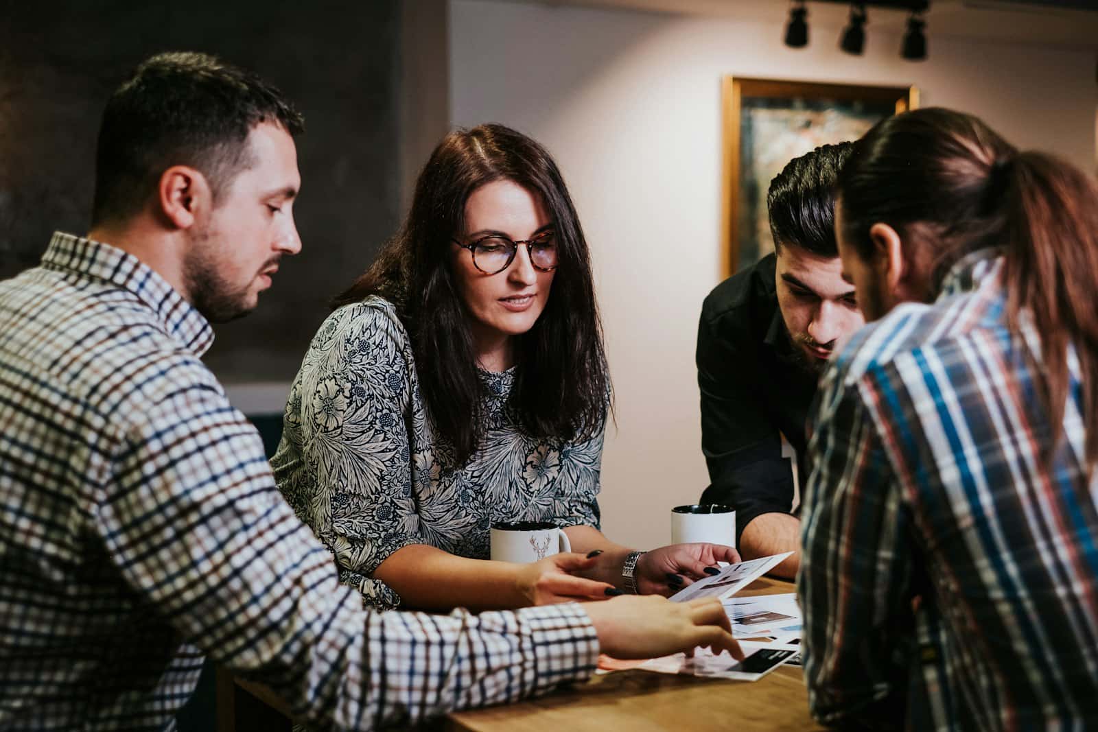 Four people reviewing documents at a wooden table