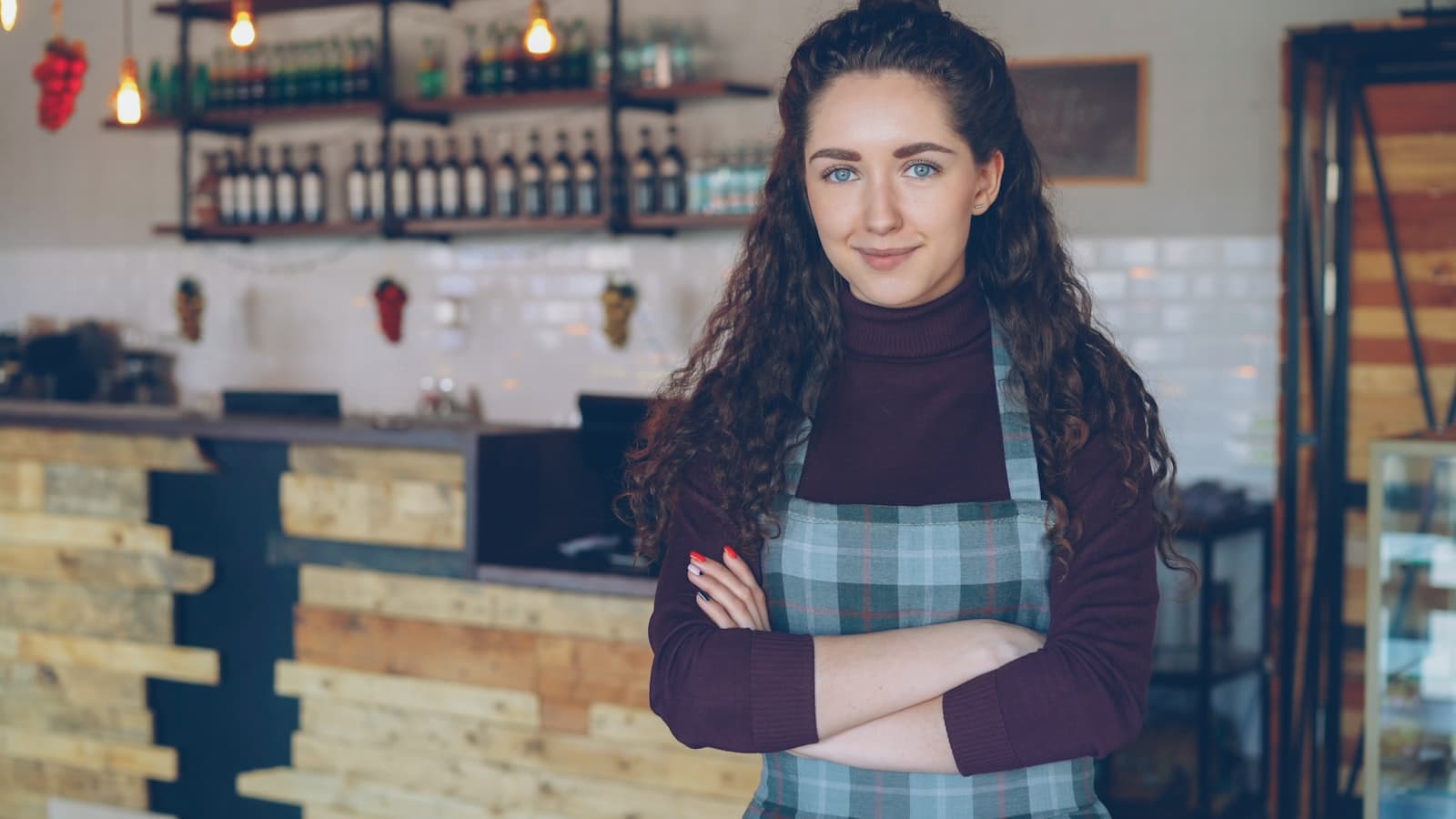 A smiling business owner standing in her coffee shop