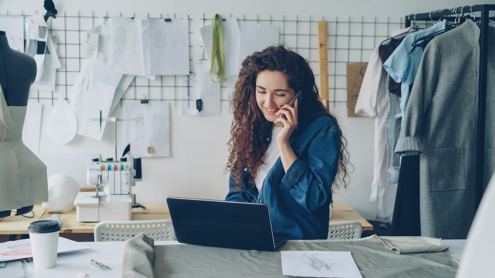 A business owner on the phone while working on a laptop